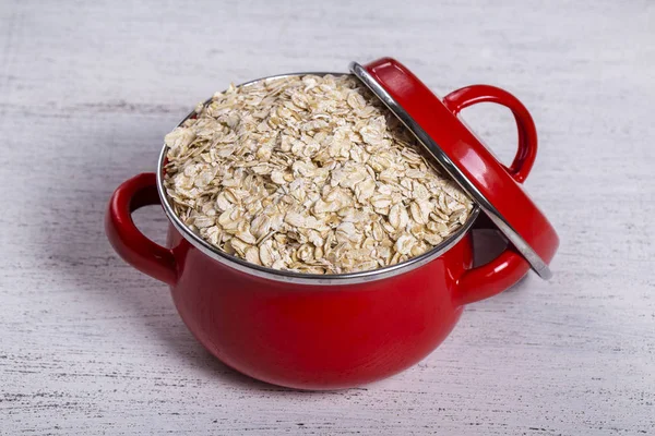 Sartén Roja Con Copos Avena Secos Sobre Fondo Blanco Madera — Foto de Stock