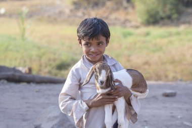 Mandu, Hindistan - 03 Şubat 2017: Goatling ile Caddesi'nde kimliği belirsiz Hint çocuk. Yoksulluk Hindistan önemli bir konudur