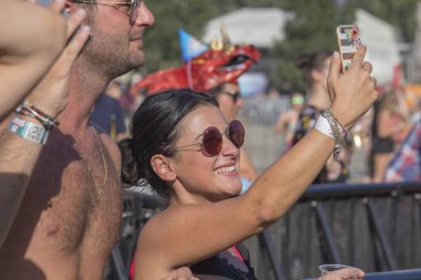 Budapeşte, Macaristan - 15 Ağustos 2017: Bilinmeyen kızlar ve çocuklar olduğunu kültür katılımcılar ve müzik festivali Sziget. Güzel kız Sziget Festivali'nde telefonda bir fotoğraf yapmak