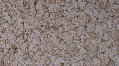 Haddelenmiş yulaf taneleri kapatın. Döndürme yulaf gevreği arka plan, makro, üstten görünüm