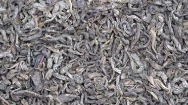 Arka plan yeşil çay yakın. Döngü döndürme. Kameranın ön kısmında döner levha ile yeşil çay, makro