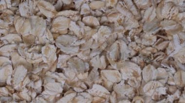 Haddelenmiş yulaf taneleri kapatın. Döndürme yulaf gevreği arka plan, makro, üstten görünüm