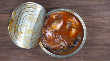 Çatal alır kullanarak üzerinden bir konserve domates soslu Hamsi balığı sardalyaları. Üstten görünüm, yakın çekim, makro
