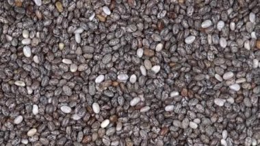 Chia tohum arka plan kazık, rotasyon loopable 4 k en iyi görünümü kapatın. Gıda arka plan. Gastronomi kavramı, organik gıda. Makro chia tohum 
