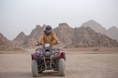 Bir Atv bir adam portresi. Sharm El Sheikh, Mısır yakınlarında çölde safari Quad bisiklet. Güçlü hızlı off-road dört tekerlekten çekiş ATV, motosiklet kumlu çölde karşı yüksek dağlar ralli.
