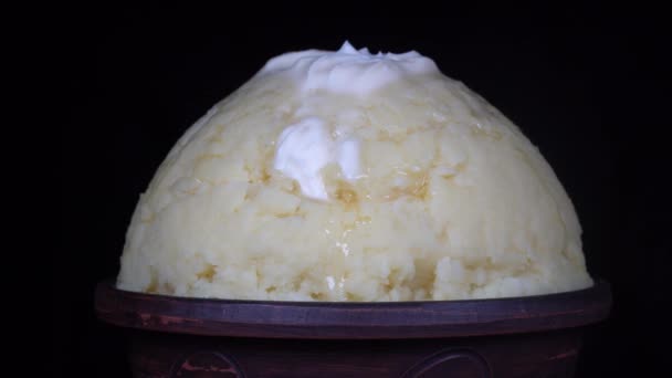 ウクライナの国民食はプレートにバターとマッシュ ポテト クローズ アップ 黒の背景でマッシュ ポテトとボウルを回転マクロ — ストック動画