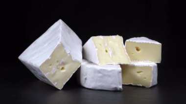 Siyah tabakta peynirli Camembert peyniri ve peynirli Brie. Siyah arka planda beyaz peynirli Camembert peyniri ve peynir. Yaklaş, macro.