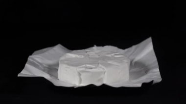 Döndürme peynir Camembert siyah arduvaz plaka üzerinde. Beyaz lezzetli parça siyah arka plan üzerine Camembert peyniri, makroyu oluşturan, yakın