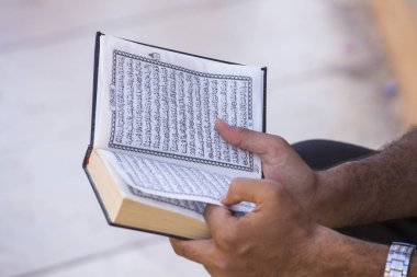 SHARM EL-SHEIKH, EGYPT - 17 Mayıs 2018: Mısırlı adam İslam 'ın kitabını okuyor, El-Kur' an kutsal bir İslam dini kitabıdır. Sharm El Sheikh, Güney Sina, Mısır