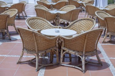 Mısır 'ın Sharm el Sheikh kentindeki Kızıl Deniz' in yanındaki plaj kafeteryasında Rattan masası ve sandalyeler.
