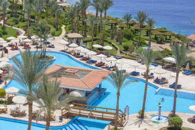 Sharm El-Sheikh, Mısır - 17 Mayıs 2018: yüzmek insanlar ve Kızıldeniz resort hotel Sharm El Sheikh, South Sinai, Mısır'ın yanındaki yüzme havuzunda güneşlenin