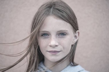 Güzel sarışın genç kız açık havada duvar arka plan üzerinde çilli kapatmak dikey