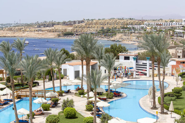 ШАРМ ЭЛЬ-САЙХ, ЕГИПТ - 24 января 2018 года: Люди купаются и загорают в бассейне рядом с Красным морем в курортном отеле Шарм-эль-Шейх, Южный Синай, Египет.
