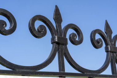 Siyah metal çit, yaklaşın. Güzel dekoratif dökme demir parmaklıklar ve sanatsal demirler. Metal bariyer