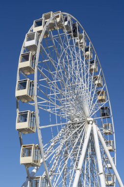 Büyük ferris wheel mavi gökyüzü arka plan üzerinde beyaz.