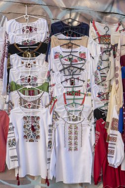 Görüntü bir işlemeli Ukraynalı Slav kadınlar ve erkekler geleneksel gömlek nakış giyim açık bit pazarı Kiev, Ukrayna. Yakın çekim. Etnik doku tasarım kumaş üzerine