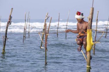 Koggala, Sri Lanka - 9 Kasım 2014: Yerel balıkçılar ahşap stilts üzerinde oturmak ve okyanusta balık yakalamak. Bu tür balık tutma için Güney Sri Lanka Hint Okyanusu'nda geleneksel
