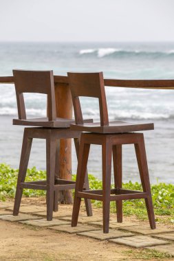Ahşap sandalye ve masa deniz suyu tropik sahilde Sri Lanka yanındaki boş kafede. Yakın çekim