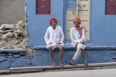 PUSHKAR, INDIA - 16 Kasım 2018: İki yaşlı bedevi adam, Pushkar Camel Mela 'nın kutsal şehri Pushkar, Rajasthan, Hindistan' da zamanında sokakta oturuyor