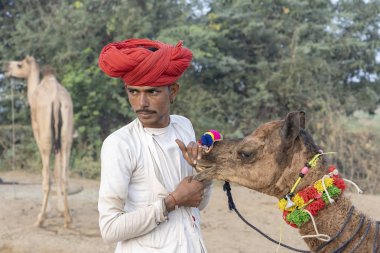 PUSHKAR, INDIA - 15 Kasım 2018: Hindistan 'ın kutsal şehri Pushkar, Rajasthan yakınlarındaki Pushkar Camel Mela sırasında çöldeki Hintli adam. Bu fuar dünyanın en büyük deve ticaret fuarı..