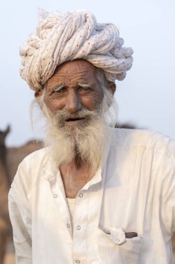 Pushkar, Hindistan - 14 Kasım 2018: Hint yaşlı adam kutsal şehir Pushkar, Rajasthan, Hindistan yakınındaki Pushkar deve Mela sırasında Thar Çölü'nde. Bu adil değil dünyanın en büyük deve Ticaret Fuarı.