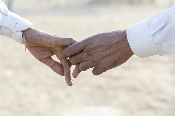 プシュカル ラージャス ターン州 インドの都市の近くのプシュカル ラクダ メラ中にカップルが手通りに クローズ アップ インドでは それはお互いを手で保持しても男性のほうが普通です — ストック写真