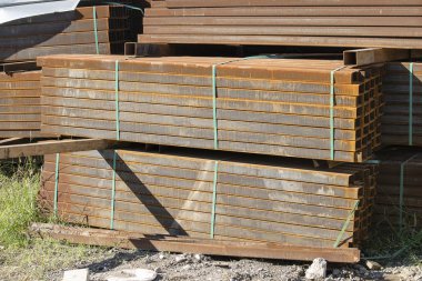 Paslı dikdörtgen metal boru paketlerine metal ürünler depoda saklanır, yakın çekim. Çelik malzemeleri, İnşaat malzemeleri.