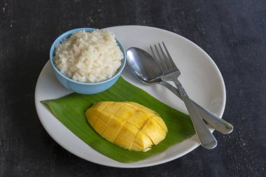 Tay tarzında tatlı, plaka üzerinde yapışkan pirinç ile mango. Sarı mango ve yapışkan pirinç olduğunu Tayland popüler geleneksel tatlı