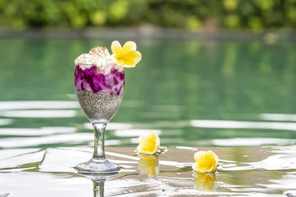 Pudín de semillas de chía con fruta roja de dragón y yogur blanco en un vaso para el desayuno en el fondo del agua de la piscina. El concepto de alimentación saludable . — Foto de Stock