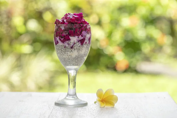 Budín de semillas de chía con fruta roja de dragón y yogur blanco en un vaso para el desayuno en el fondo de la naturaleza. El concepto de alimentación saludable . — Foto de Stock