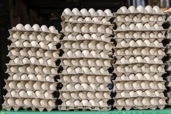 Stacks of white eggs in trays on local street market in India
