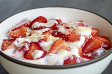 Kırmızı çilek ve beyaz yoğurt brulee. Mevsimlik çilek, mükemmel olgunlaşmış takozlar ile kahvaltıda meyve tatlısı