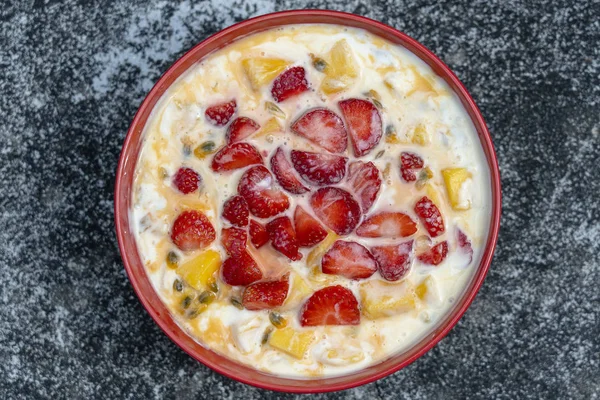 Manga, maracujá, morango e iogurte brulee. Sobremesa de fruto em café da manhã com cunhas de mangas de estação perfeitamente maduras e morango, polpa de maracujá fresca coberta — Fotografia de Stock