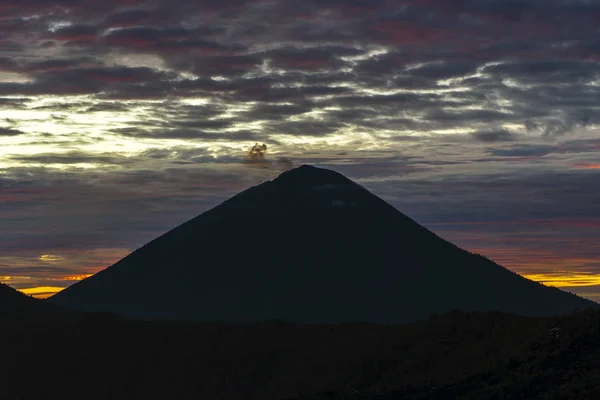 Bewölkte Landschaft mit Silhouetten von Vulkanbergen bei Sonnenaufgang. bali, indonesien — Stockfoto