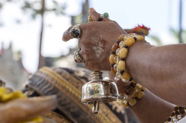 Ubud, Island Bali, Endonezya merkezi sokakta Bade kremasyon töreni sırasında rahibin elleri . Closeup