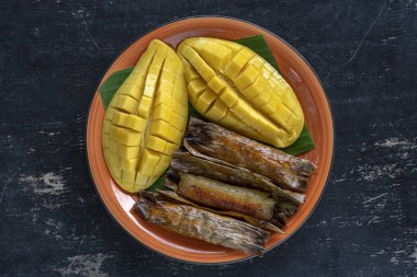 Tay tarzı tatlı, palmiye yaprakları muz yapışkan pirinç sarı Mango. Sarı mango ve yapışkan pirinç Tayland popüler geleneksel gıda. Closeup