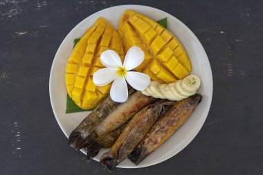 Tay tarzı tatlı, palmiye yaprakları muz yapışkan pirinç sarı Mango. Sarı mango ve yapışkan pirinç Tayland popüler geleneksel gıda. Closeup
