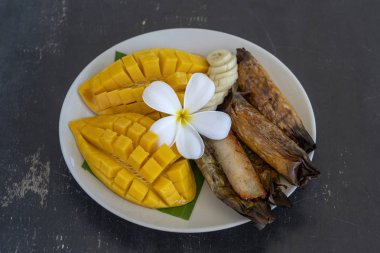 Tay tarzı tatlı, palmiye yaprakları muz yapışkan pirinç sarı Mango. Sarı mango ve yapışkan pirinç Tayland popüler geleneksel gıda. Closeup