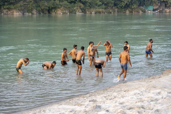 Indičtí hoši plavou v posvátné vodě řeky Ganges ve městě Rishikesh, Indie. — Stock fotografie