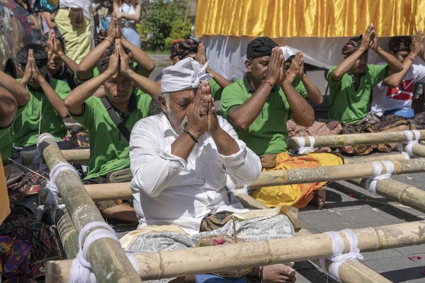 Oración de los hombres indonesios durante la ceremonia de cremación de Bade en la calle central de Ubud, Isla Bali, Indonesia — Foto de Stock