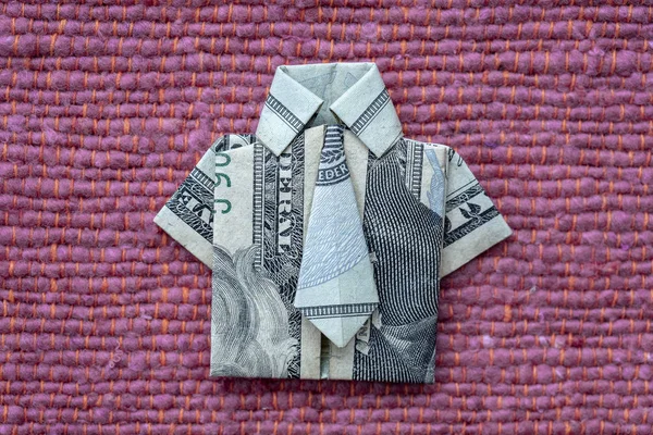 Koszula origami wykonana z banknotu dolara na czerwonym tle tkaniny. Zbliżenie. Koszulka Dollar Bill — Zdjęcie stockowe