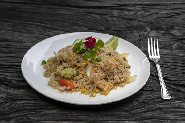 Arroz frito con gambas y verduras en un plato blanco sobre una vieja mesa de madera, de cerca. Cocina tailandesa, comida tailandesa —  Fotos de Stock