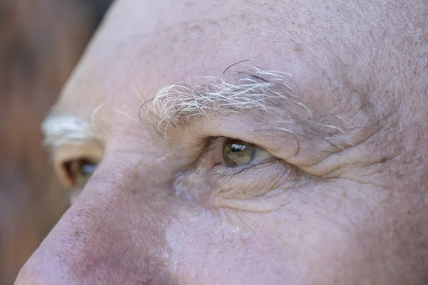 Closeup eye of caucasian old man. Portrait of old man outdoors. Caucasian male face background, close up eyes, macro — Stock Photo, Image