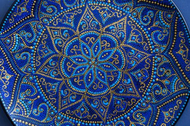 Mavi ve altın rengi nde dekoratif seramik tabak, boyalı tabaklar, closeup. Akrilik boyalar ile boyanmış dekoratif porselen plaka, el işi