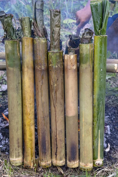 Ardiente arroz de bambú en la cocina tradicional, comida asiática. Ubud, isla Bali, Indonesia. Primer plano. Arroz pegajoso quemado con leche de coco dulce en inyección de bambú — Foto de Stock