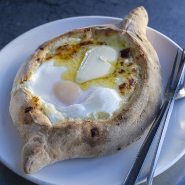 Restoranda Adjarian Khachapuri. Peynirli ve yumurtalı turta. Lezzetli Gürcü mutfağı..