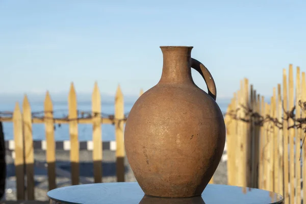 Grande brocca di terracotta si trova su un tavolo sulla riva vicino all'acqua di mare a Batumi, Georgia . — Foto Stock