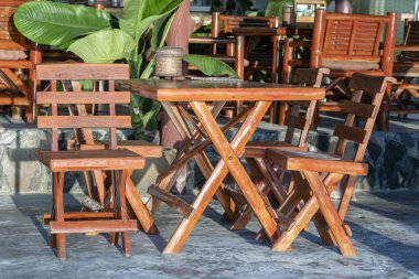 Plajın yanındaki boş kafede tahta masa ve sandalyeler. Koh Phangan Adası, Tayland