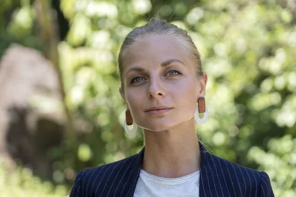 Hermosa chica rubia caucásica en un traje de negocios en el fondo de la naturaleza. Un retrato de una joven mujer de negocios en un jardín tropical, Tailandia — Foto de Stock