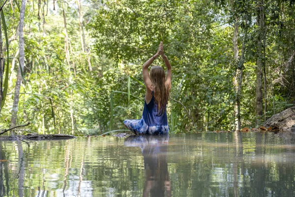 Bella donna che pratica yoga vicino all'acqua turchese della cascata a cascata nella foresta pluviale tropicale profonda, isola di Koh Phangan, Thailandia — Foto Stock